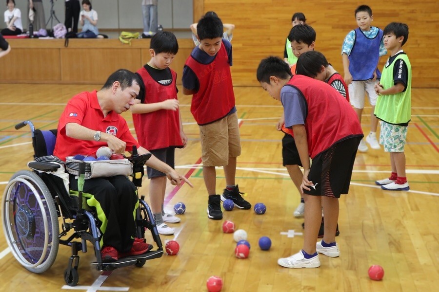 守山区子ども実行委員がボッチャ選手に戦略を相談する様子の写真