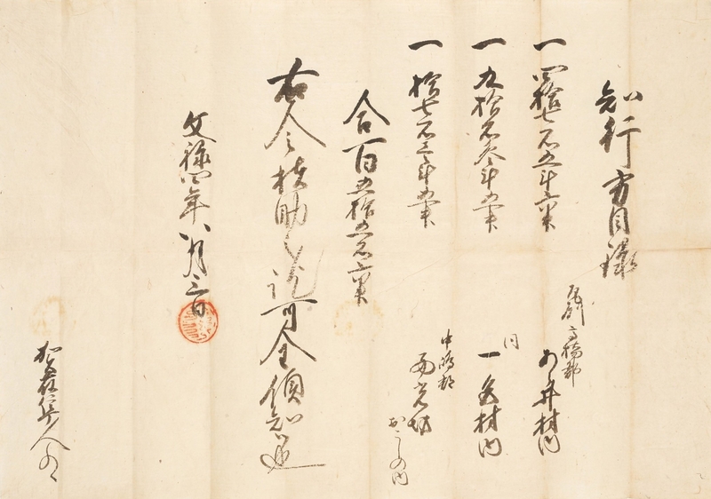 古い和紙に墨で文字が縦に書かれた文書の写真。赤い朱印が押してある。