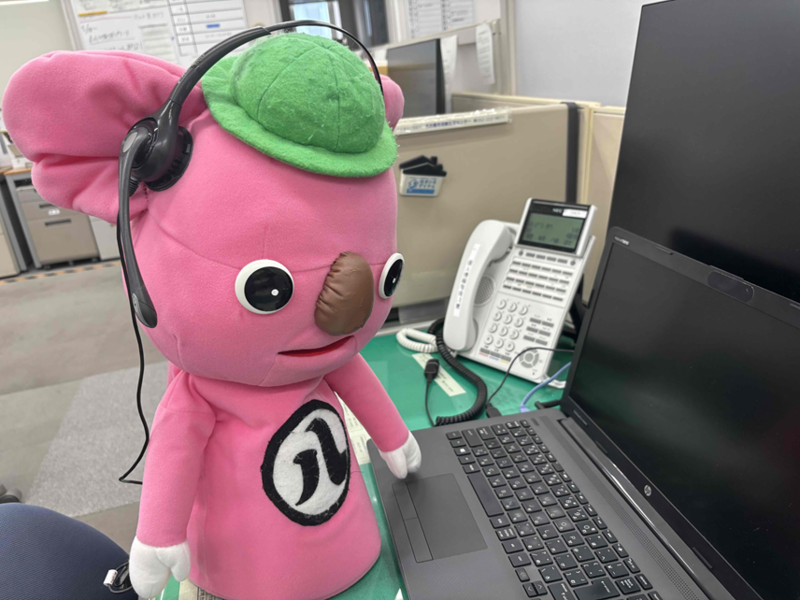 名古屋市消費生活センターのマスコットキャラクターのハッピーが電話相談に対応する様子の写真