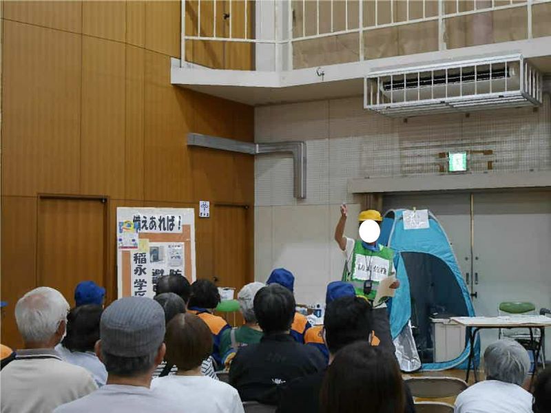 簡易パック式トイレや、稲永学区で保管している備蓄品を説明する様子