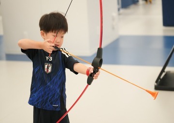 写真:ユニバーサルスポーツフェスでアーチェリーの体験をする子ども