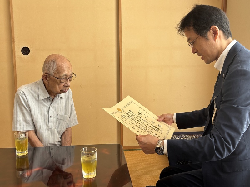 写真：鈴木区長がお祝い状を読み上げる様子