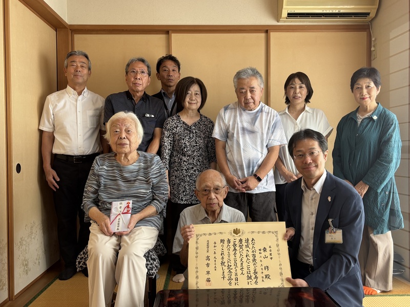 写真：桒山さんご家族と訪問団での記念撮影