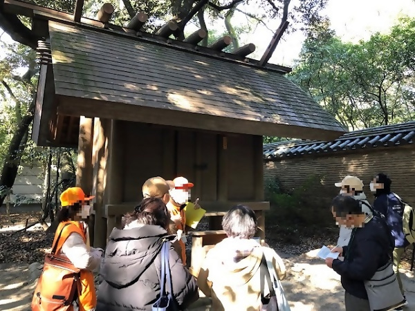 神明造の社殿にいて説明する歴史ボランティアガイドさん
