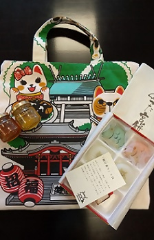 招き猫のバッグとあつた宮餅
