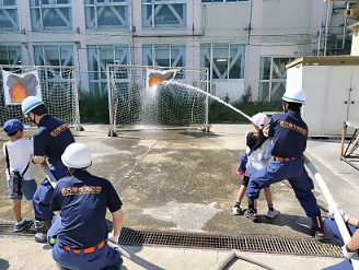 児童と一緒に放水訓練をする様子