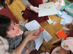 足に赤のスタンプをつける子ども
