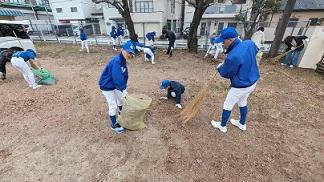 掃き掃除をする少年野球チームの人たち