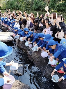 幼児さんたちがメダカを放流しているところ
