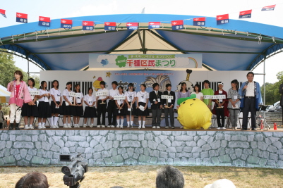 中学生と市長と矢野きよ実さんがステージに並んでいる様子