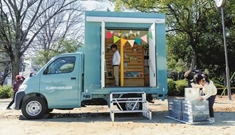 自動車図書館で子供が本を読む様子