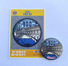 100周年缶バッジとマンホールカードの写真