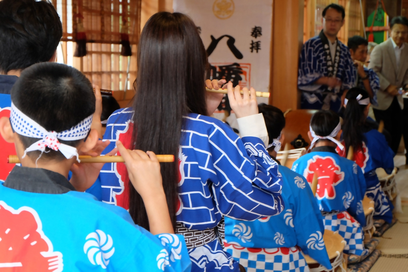 建物の中で笛や太鼓を演奏する人たちの写真