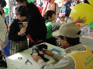 区民まつりの缶バッジ作成の様子の写真