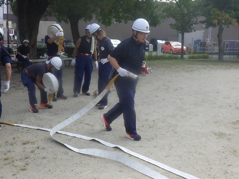 消防団がホース延長訓練をしています。