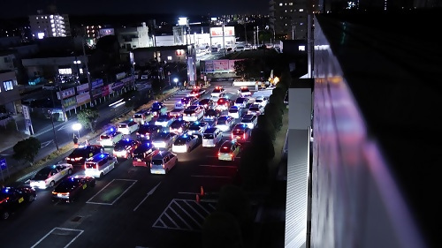青色防犯パトロール車両が区役所駐車場からパトロールへ出発する様子