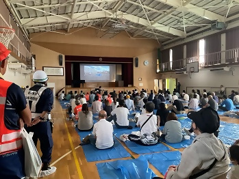 体育館から運動場の救助訓練を見る参加者